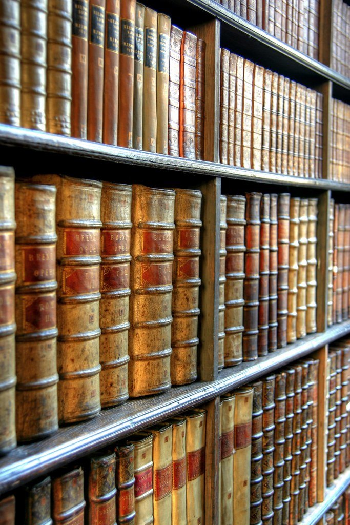Étagères d'archives contenant d'anciens documents historiques reliés, illustration de l'analyse de documents en histoire au brevet
