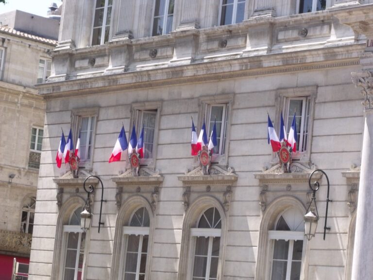 Façade d'un hôtel de ville avec drapeaux français et emblèmes de la République, illustration des sujets d'EMC et de citoyenneté au brevet