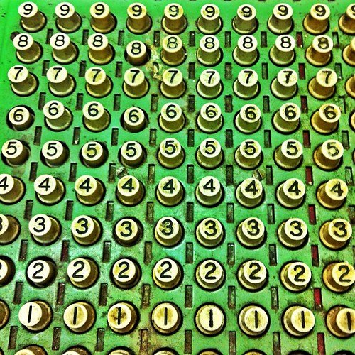 Gros plan sur les touches chiffrées d'une ancienne machine à calculer, illustration des exercices de calcul mental niveau 3e